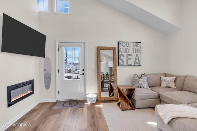 123 W Cove Way, Lavallette, NJ 08735 - living room featuring wood finished floors, healthy amount of natural light, a glass covered fireplace, high vaulted ceiling, and baseboards