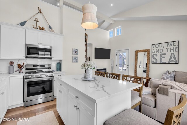 123 W Cove Way, Lavallette, NJ 08735 - kitchen featuring appliances with stainless steel finishes, open floor plan, a center island, white cabinetry, and high vaulted ceiling
