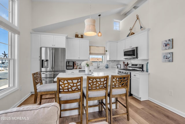 123 W Cove Way, Lavallette, NJ 08735 - kitchen with stainless steel appliances, high vaulted ceiling, white cabinets, beam ceiling, and light wood finished floors