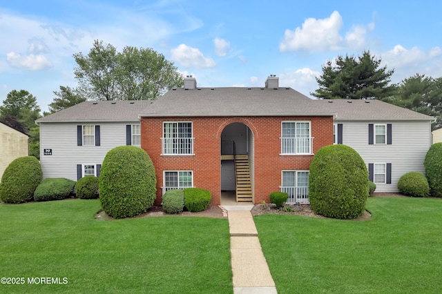717 Zlotkin Cir Unit 1, Freehold, NJ 07728 - view of front of house with a chimney, a front lawn, brick siding, and a shingled roof