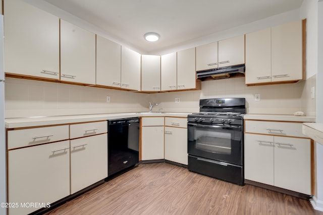717 Zlotkin Cir Unit 1, Freehold, NJ 07728 - kitchen with black appliances, under cabinet range hood, light countertops, light wood-style floors, and tasteful backsplash
