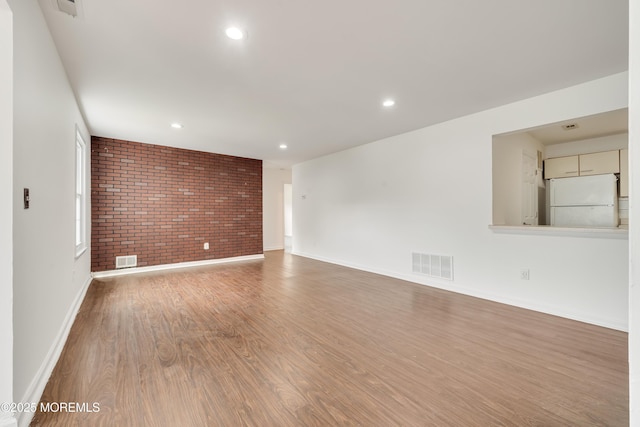 717 Zlotkin Cir Unit 1, Freehold, NJ 07728 - unfurnished room with brick wall, wood finished floors, baseboards, and recessed lighting