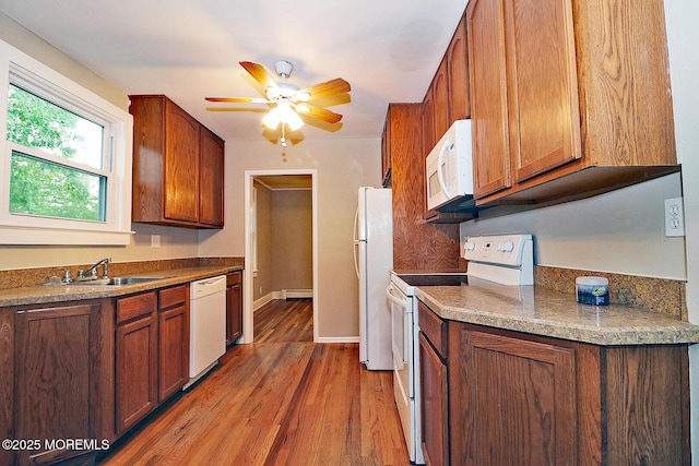 1600 Lawrence Ave, Toms River, NJ 08757 - kitchen featuring white appliances, a sink, light wood-style floors, ceiling fan, and brown cabinetry