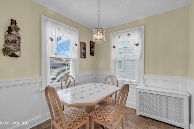 143 Emerson St, Carteret, NJ 07008 - dining space featuring radiator, a wainscoted wall, a decorative wall, and a chandelier