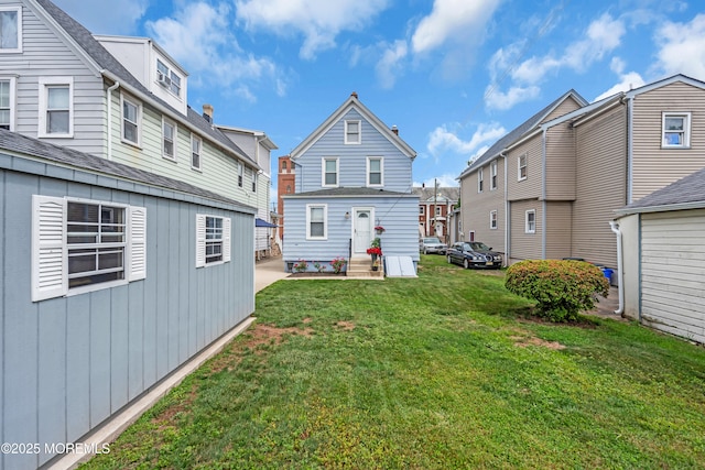 143 Emerson St, Carteret, NJ 07008 - rear view of house featuring a residential view, a lawn, and entry steps