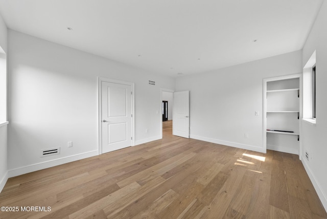 4 Penny Ct, East Brunswick, NJ 08816 - unfurnished bedroom with light wood finished floors, baseboards, and a walk in closet