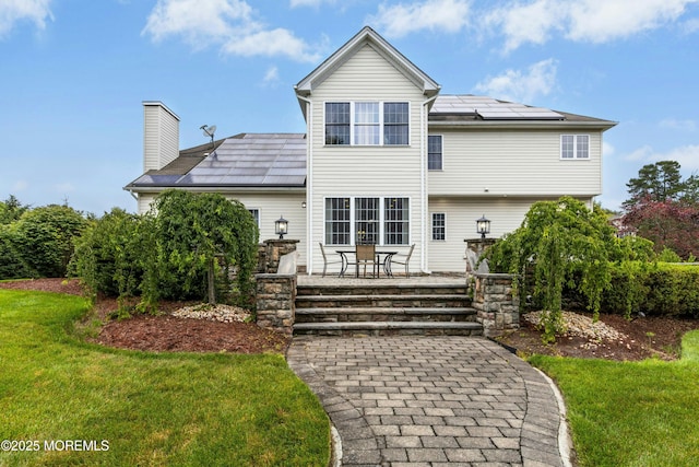 7 Topaz Dr, Jackson, NJ 08527 - rear view of property featuring roof mounted solar panels, a yard, a chimney, and a patio area