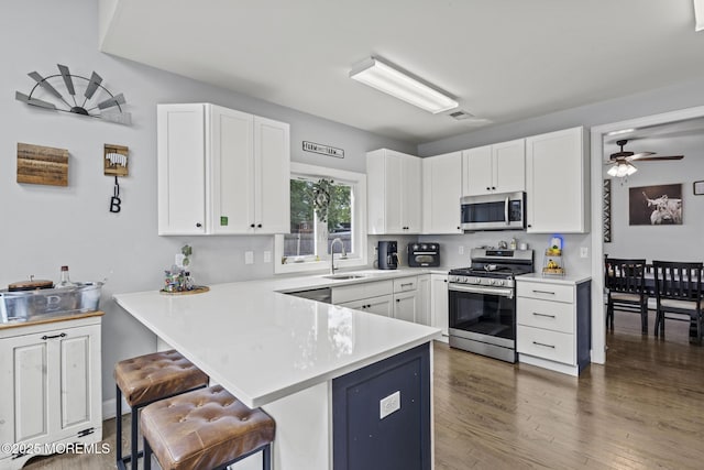 62 E 5th St, Howell, NJ 07731 - kitchen with appliances with stainless steel finishes, a breakfast bar, a peninsula, light countertops, and white cabinets