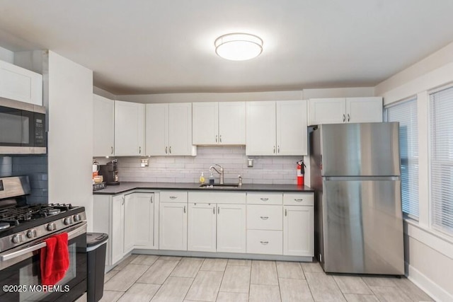 147 Joseph St, East Brunswick, NJ 08816 - kitchen with stainless steel appliances, backsplash, dark countertops, and white cabinetry