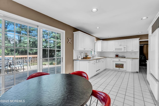 330 Green Grove Rd, Ocean Twp, NJ 07712 - kitchen featuring white appliances, light tile patterned floors, backsplash, a sink, and white cabinetry