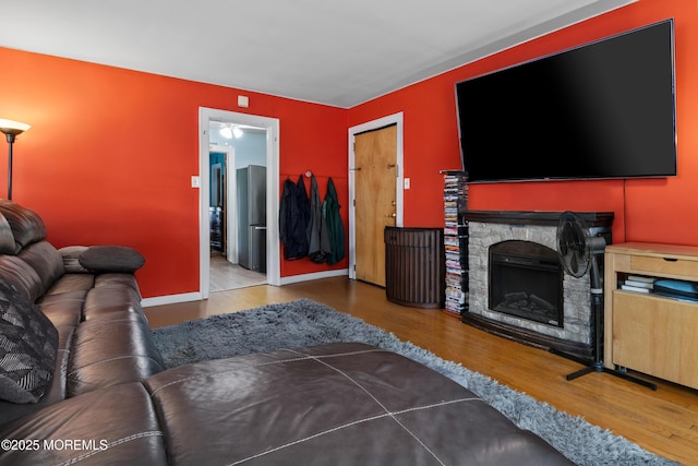 1020 Raritan Ave, Highland Park, NJ 08904 - living room with wood finished floors, a stone fireplace, and baseboards