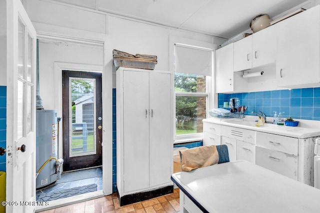 110 2nd Ave, Seaside Park, NJ 08752 - kitchen with gas water heater, light countertops, white cabinetry, and plenty of natural light