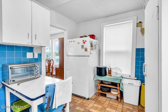 110 2nd Ave, Seaside Park, NJ 08752 - kitchen featuring freestanding refrigerator, white cabinetry, and brick patterned floors