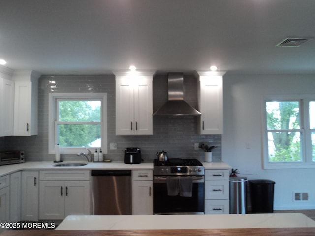 127 Hulick St, Long Branch, NJ 07740 - kitchen with appliances with stainless steel finishes, wall chimney range hood, a sink, and light countertops
