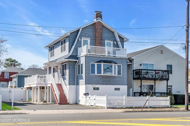 1204 River Rd, Belmar, NJ 07719 - dutch colonial with a fenced front yard, a chimney, a gate, stairs, and a balcony