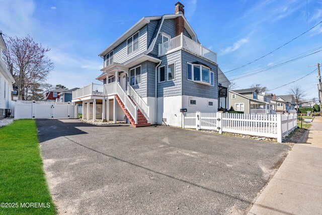 1204 River Rd, Belmar, NJ 07719 - view of front of property featuring a gate, a chimney, stairway, a balcony, and a gambrel roof