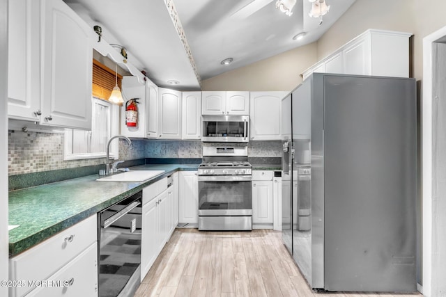 830 Atlantic City Blvd, Bayville, NJ 08721 - kitchen featuring appliances with stainless steel finishes, a sink, lofted ceiling, backsplash, and white cabinetry