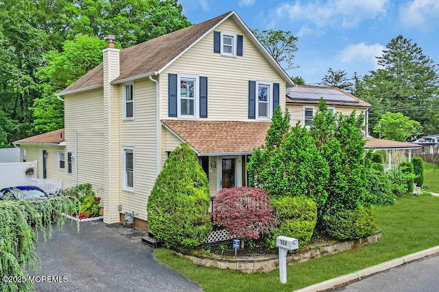 908 Green Grove Rd, Ocean Twp, NJ 07712 - view of front of property featuring a chimney, roof mounted solar panels, and roof with shingles