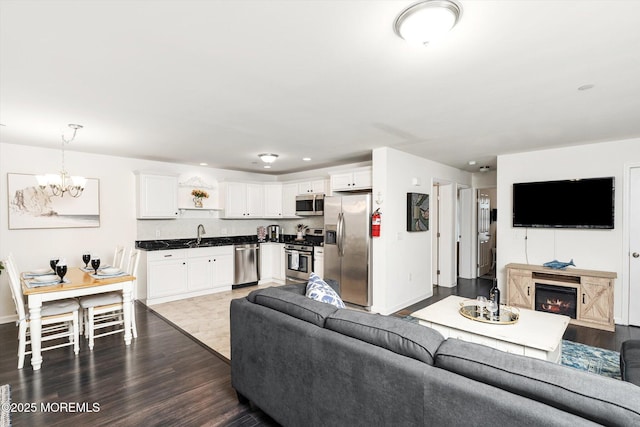 2033 Rte 35 Unit 3, Seaside Heights, NJ 08751 - living area with a chandelier, dark wood-style floors, baseboards, a glass covered fireplace, and recessed lighting