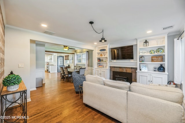13 Poplar Ave, Fair Haven, NJ 07704 - living room with crown molding, a tiled fireplace, wood finished floors, ceiling fan, and recessed lighting
