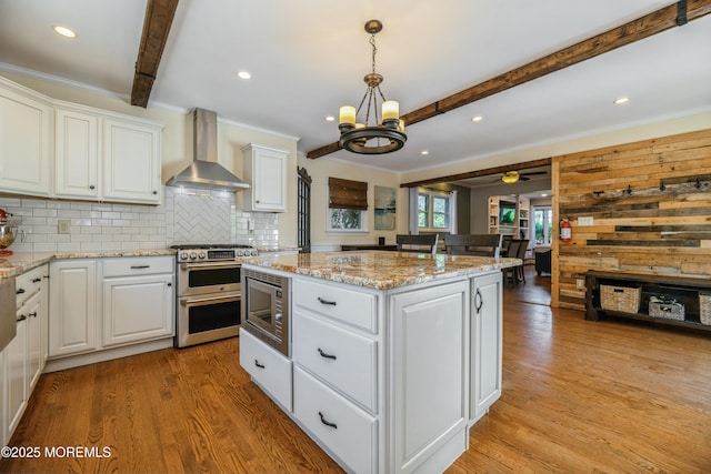 13 Poplar Ave, Fair Haven, NJ 07704 - kitchen with stainless steel appliances, wall chimney exhaust hood, a kitchen island, beamed ceiling, and light wood-style floors