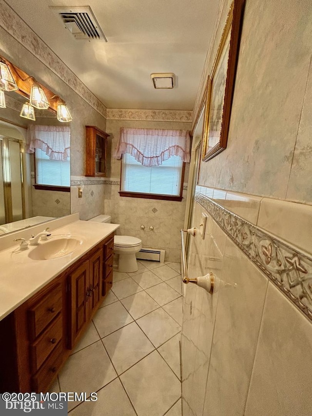 504 Windsor St, Forked River, NJ 08731 - bathroom with baseboard heating, healthy amount of natural light, tile walls, toilet, and tile patterned floors