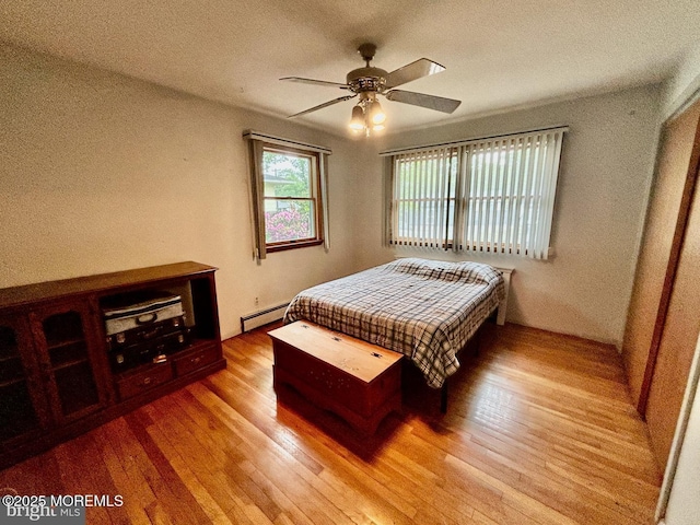 504 Windsor St, Forked River, NJ 08731 - bedroom featuring a baseboard heating unit, wood finished floors, a textured ceiling, and a ceiling fan