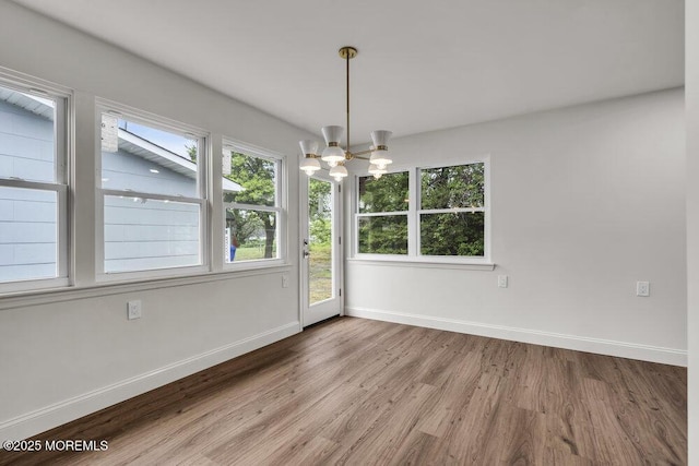85 Central Blvd, Brick, NJ 08724 - unfurnished dining area with wood finished floors, baseboards, a chandelier, and healthy amount of natural light