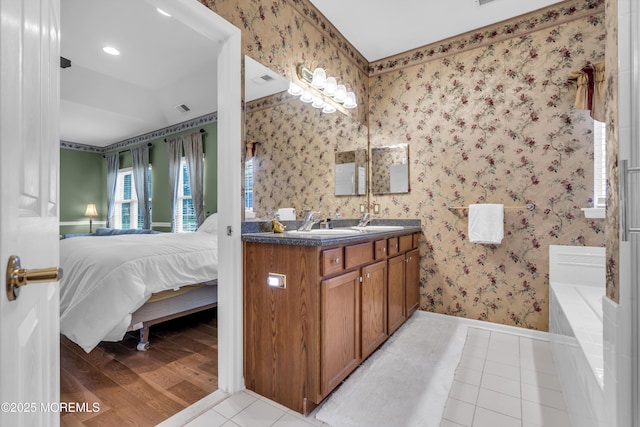 46 Pancoast Rd, Waretown, NJ 08758 - ensuite bathroom featuring double vanity, a bathtub, tile patterned flooring, baseboards, and wallpapered walls