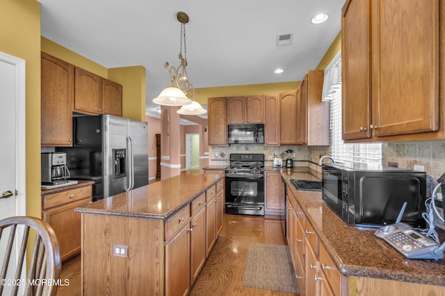 46 Pancoast Rd, Waretown, NJ 08758 - kitchen with black appliances, a sink, a center island, brown cabinetry, and recessed lighting