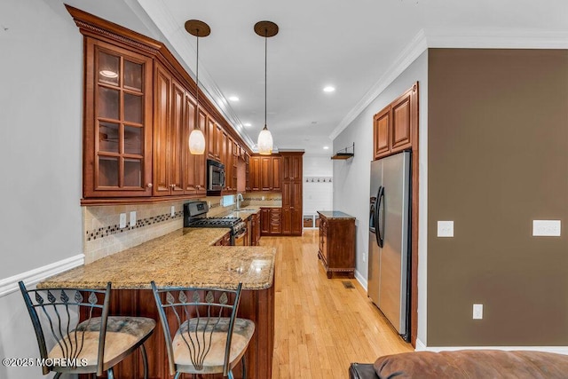 85 Main Bayway, Toms River, NJ 08753 - kitchen featuring appliances with stainless steel finishes, a sink, crown molding, light stone countertops, and a peninsula