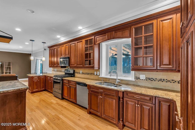 85 Main Bayway, Toms River, NJ 08753 - kitchen featuring appliances with stainless steel finishes, a sink, a peninsula, hanging light fixtures, and brown cabinets