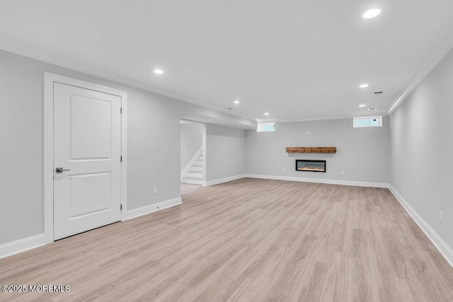 909 Leighton Ave, Point Pleasant, NJ 08742 - below grade area with recessed lighting, light wood-type flooring, a glass covered fireplace, stairs, and crown molding