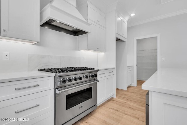 909 Leighton Ave, Point Pleasant, NJ 08742 - kitchen with premium range hood, high end stove, light countertops, ornamental molding, and white cabinets