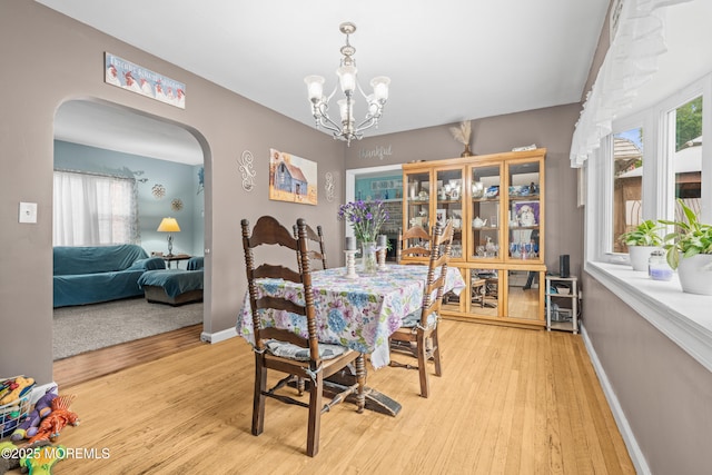 175 W Shore Ave, Bogota, NJ 07603 - dining space featuring arched walkways, light wood-style floors, a chandelier, and baseboards