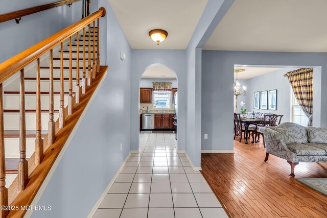 104 Plumstead Dr, Freehold, NJ 07728 - entryway featuring arched walkways, stairway, baseboards, a chandelier, and light tile patterned flooring