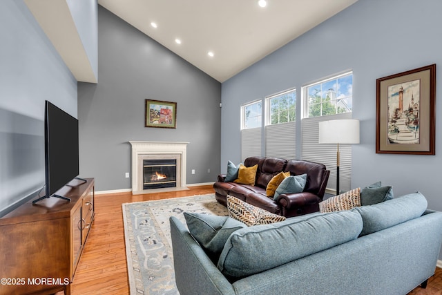 104 Plumstead Dr, Freehold, NJ 07728 - living area featuring high vaulted ceiling, recessed lighting, a fireplace with flush hearth, baseboards, and light wood finished floors