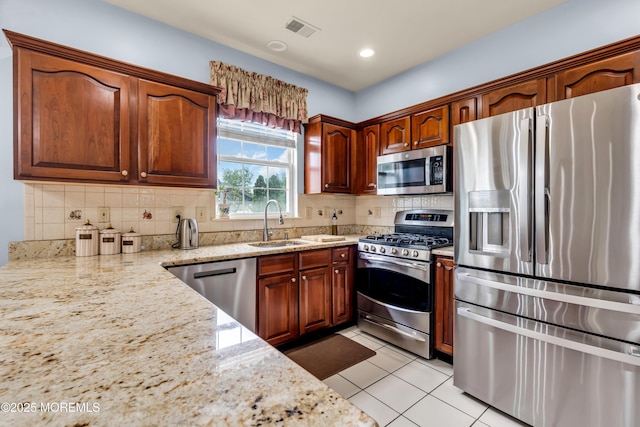 104 Plumstead Dr, Freehold, NJ 07728 - kitchen featuring stainless steel appliances, a sink, decorative backsplash, light stone counters, and light tile patterned flooring