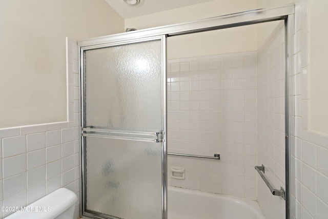 9D Dove St, Manchester, NJ 08759 - bathroom featuring tile walls, combined bath / shower with glass door, toilet, and a wainscoted wall