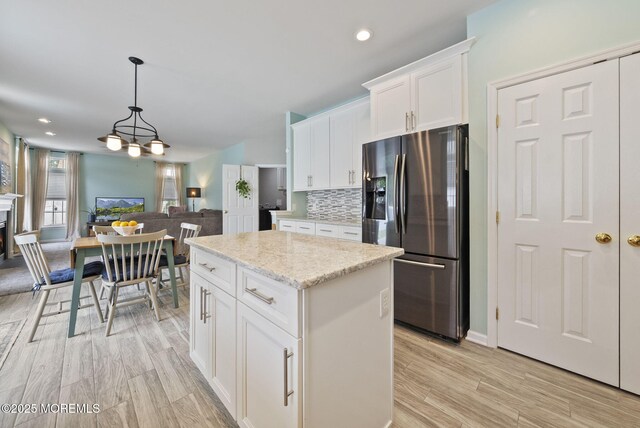 10 Butternut Ln, Bayville, NJ 08721 - kitchen featuring stainless steel fridge with ice dispenser, a center island, tasteful backsplash, open floor plan, and light wood-style flooring