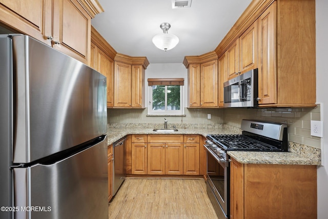 70 Lexington Cir, Matawan, NJ 07747 - kitchen with stainless steel appliances, a sink, tasteful backsplash, light wood-style floors, and light stone countertops