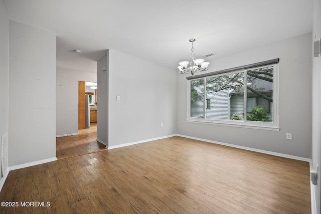 70 Lexington Cir, Matawan, NJ 07747 - empty room with a chandelier, wood finished floors, and baseboards