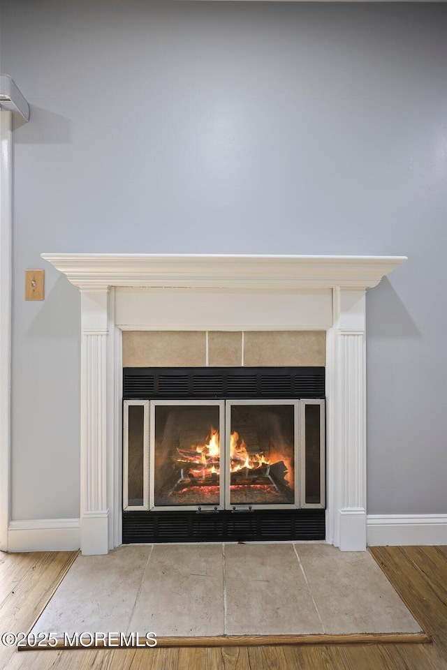 70 Lexington Cir, Matawan, NJ 07747 - detailed view of a tile fireplace, baseboards, and wood finished floors
