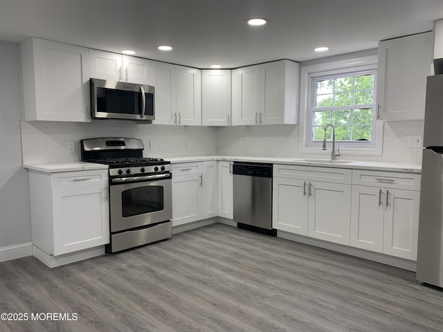 219 Hyers St, Toms River, NJ 08753 - kitchen with appliances with stainless steel finishes, a sink, light countertops, white cabinets, and decorative backsplash