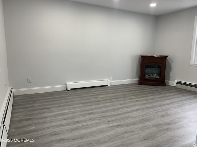 219 Hyers St, Toms River, NJ 08753 - unfurnished living room with baseboard heating, baseboards, recessed lighting, wood finished floors, and a glass covered fireplace