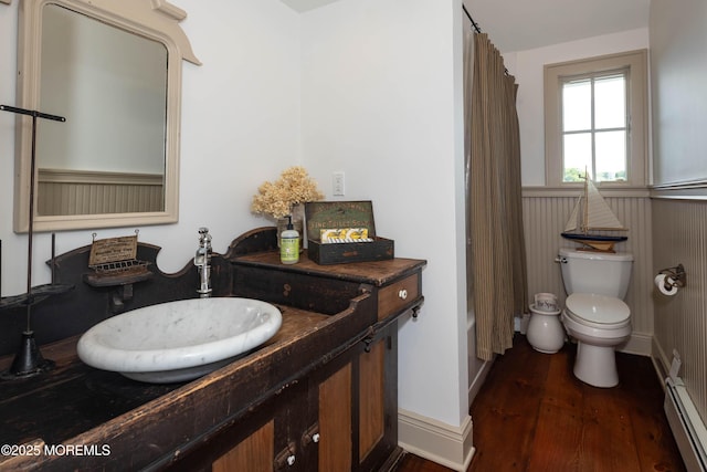 1 Beechwood Ter, Matawan, NJ 07747 - bathroom featuring wood finished floors, a baseboard radiator, toilet, a wainscoted wall, and vanity