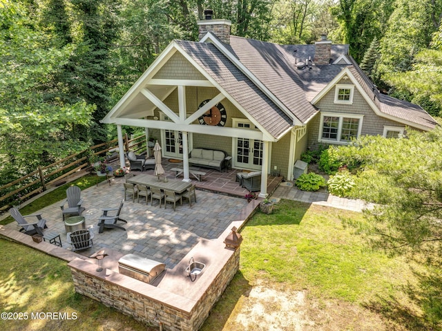 1 Beechwood Ter, Matawan, NJ 07747 - back of property featuring french doors, a chimney, a patio, an outdoor living space with a fire pit, and a shingled roof
