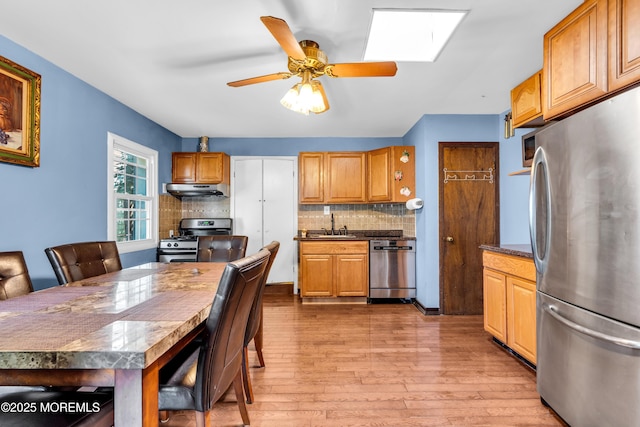2419 Mallow St, Point Pleasant, NJ 08742 - kitchen with stainless steel appliances, under cabinet range hood, light wood-style flooring, decorative backsplash, and ceiling fan