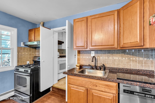 2419 Mallow St, Point Pleasant, NJ 08742 - kitchen with appliances with stainless steel finishes, a sink, under cabinet range hood, a baseboard heating unit, and decorative backsplash