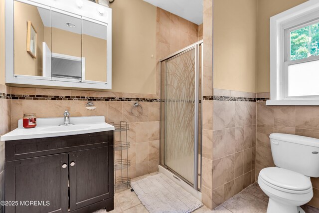 2419 Mallow St, Point Pleasant, NJ 08742 - bathroom featuring tile walls, toilet, vanity, a shower stall, and tile patterned flooring